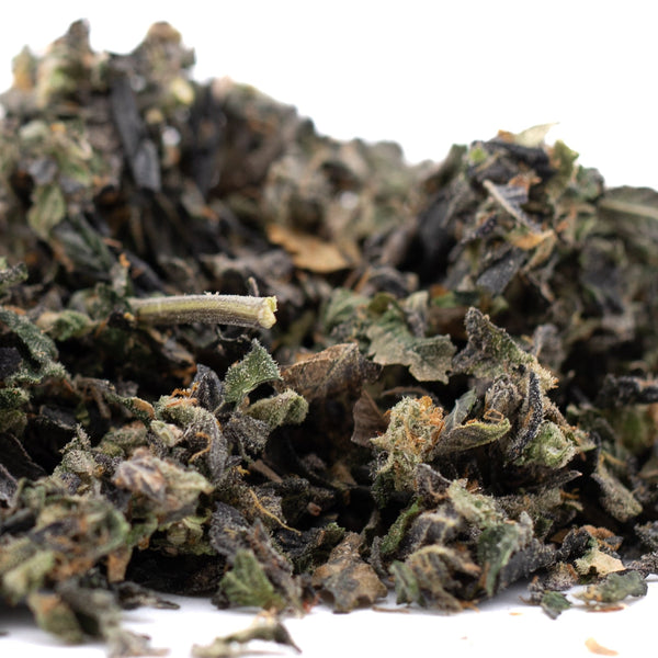 Dried green herbs pile showcasing Lemon OG Indoor Trim with THCA trim and sugar leaves